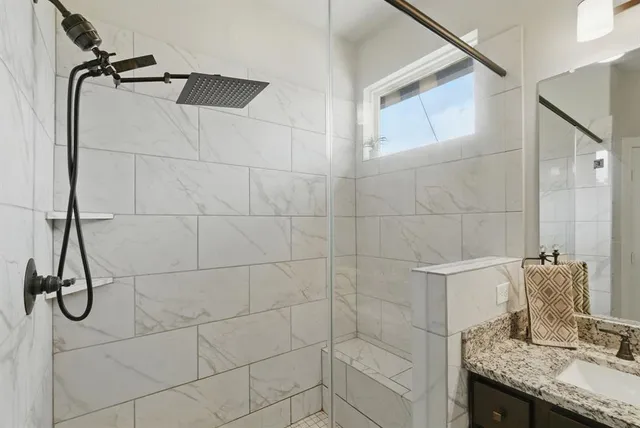 a bathroom with a granite countertop shower and a sink