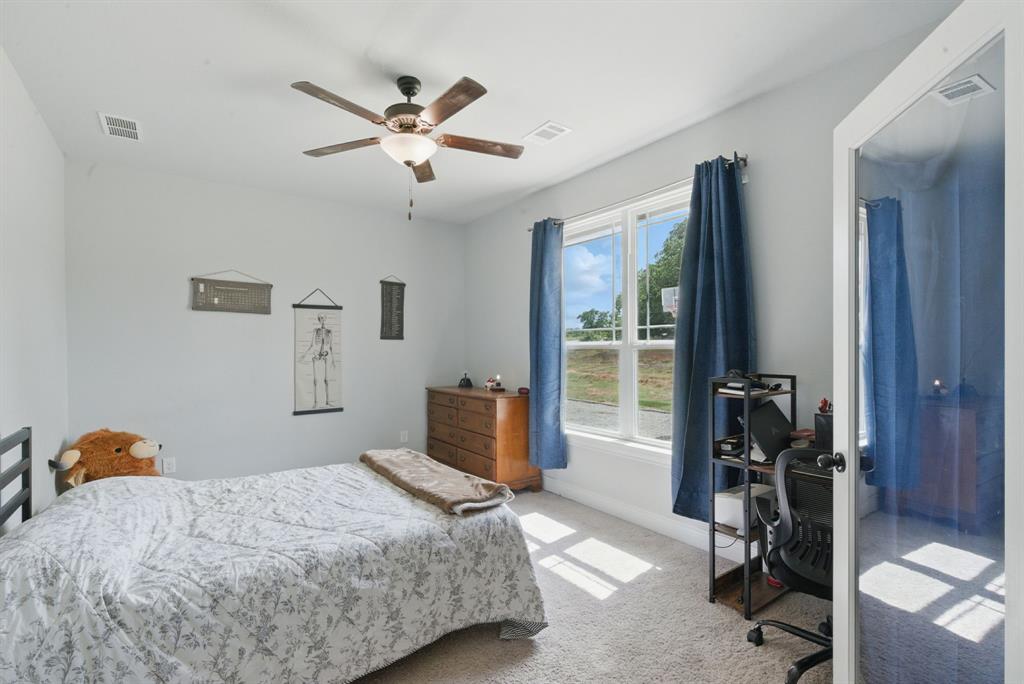 3385 Dps Tower Road Perrin, TX 76486 - Photo 26 of 35 a bedroom with a bed and a chandelier