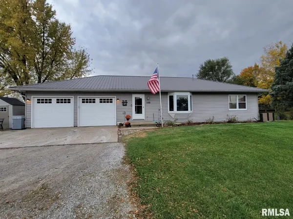 a front view of house with yard and garage