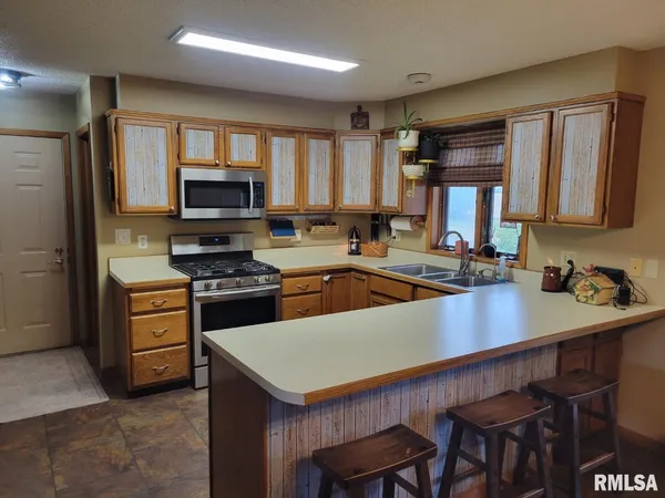 a kitchen with stainless steel appliances a refrigerator stove and microwave