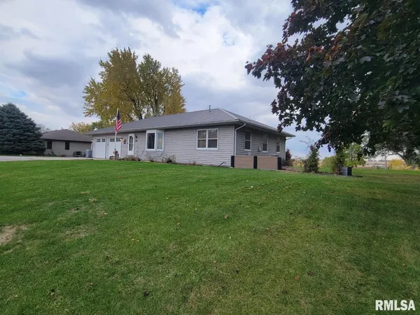 a view of a house with a big yard and large trees