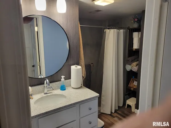 a bathroom with a granite countertop sink mirror and vanity