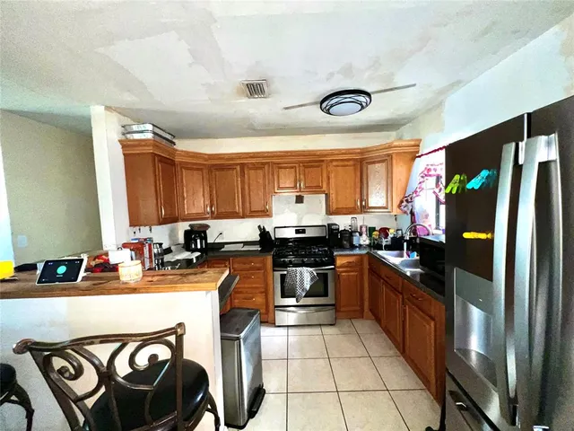 a kitchen with stainless steel appliances granite countertop a stove a sink and a refrigerator