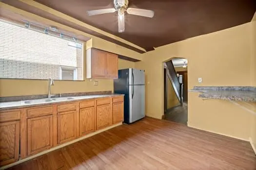 a kitchen with stainless steel appliances granite countertop a refrigerator a sink and a stove