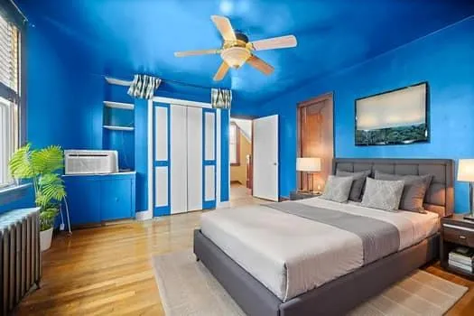 a bedroom with a large bed and a chandelier