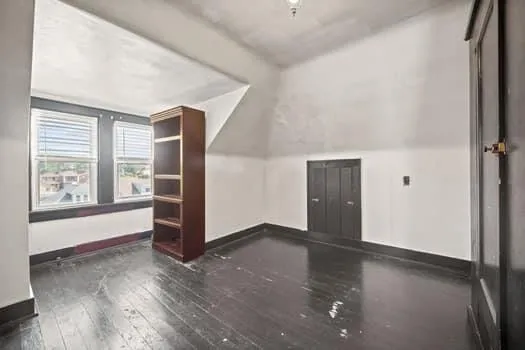 an empty room with windows and closet