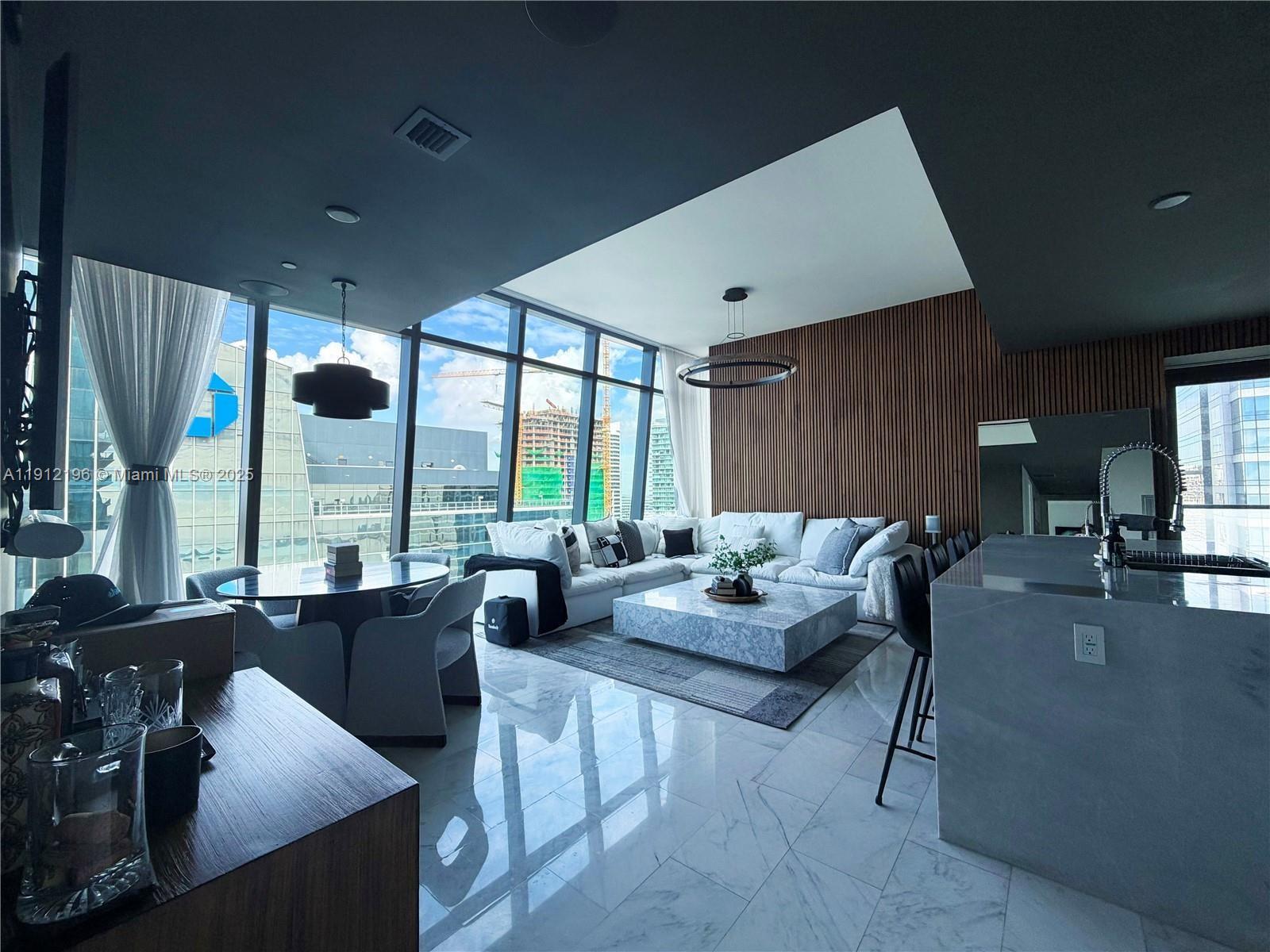 a living room with furniture and large windows