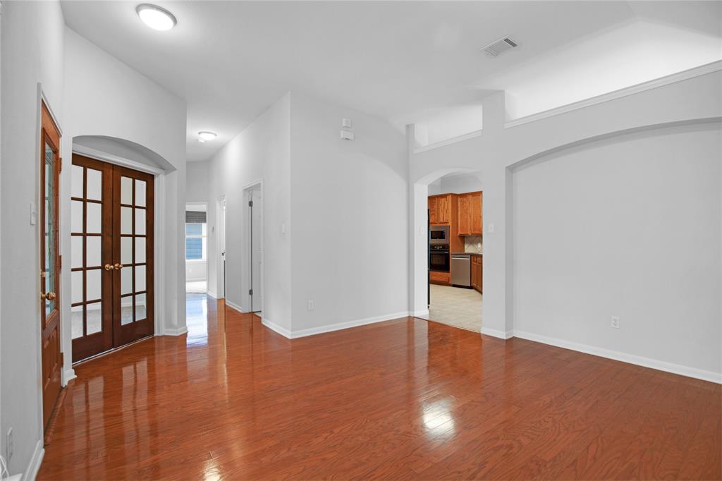 281 Hutton Kyle, TX 78640 - Photo 10 of 37 Rich hardwood floors welcome you into this bright, inviting living space, with an arched entryway leading to the kitchen.
