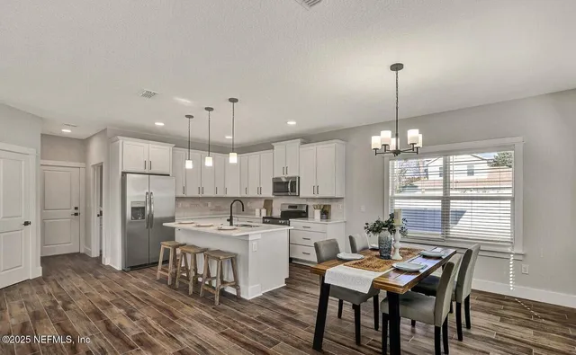 a bedroom with a large bed chandelier and a window