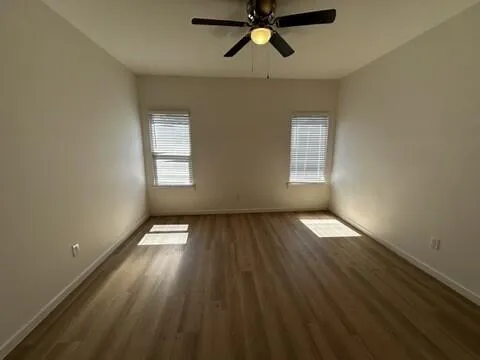 a view of empty room with wooden floor and window
