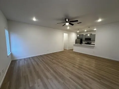 wooden floor in an empty room with a kitchen
