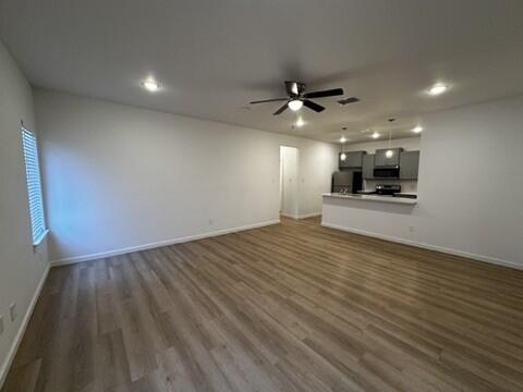 5511 Itasca Street Lubbock, TX 79416 - Photo 3 of 21 wooden floor in an empty room with a kitchen