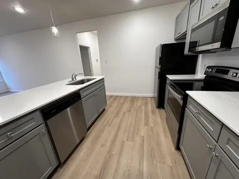 a kitchen with stainless steel appliances a sink stove and refrigerator