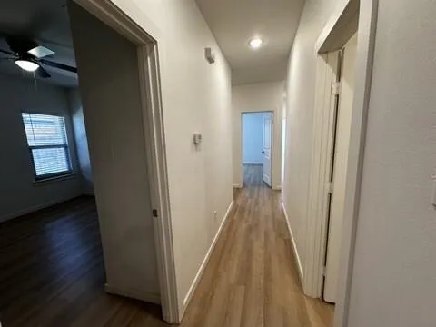 a view of a hallway with wooden floor and entryway