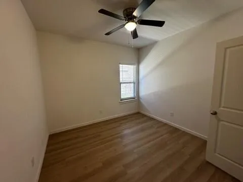 an empty room with windows and fan