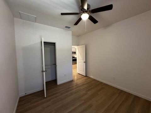 5511 Itasca Street Lubbock, TX 79416 - Photo 10 of 21 an empty room with wooden floor ceiling fan and windows