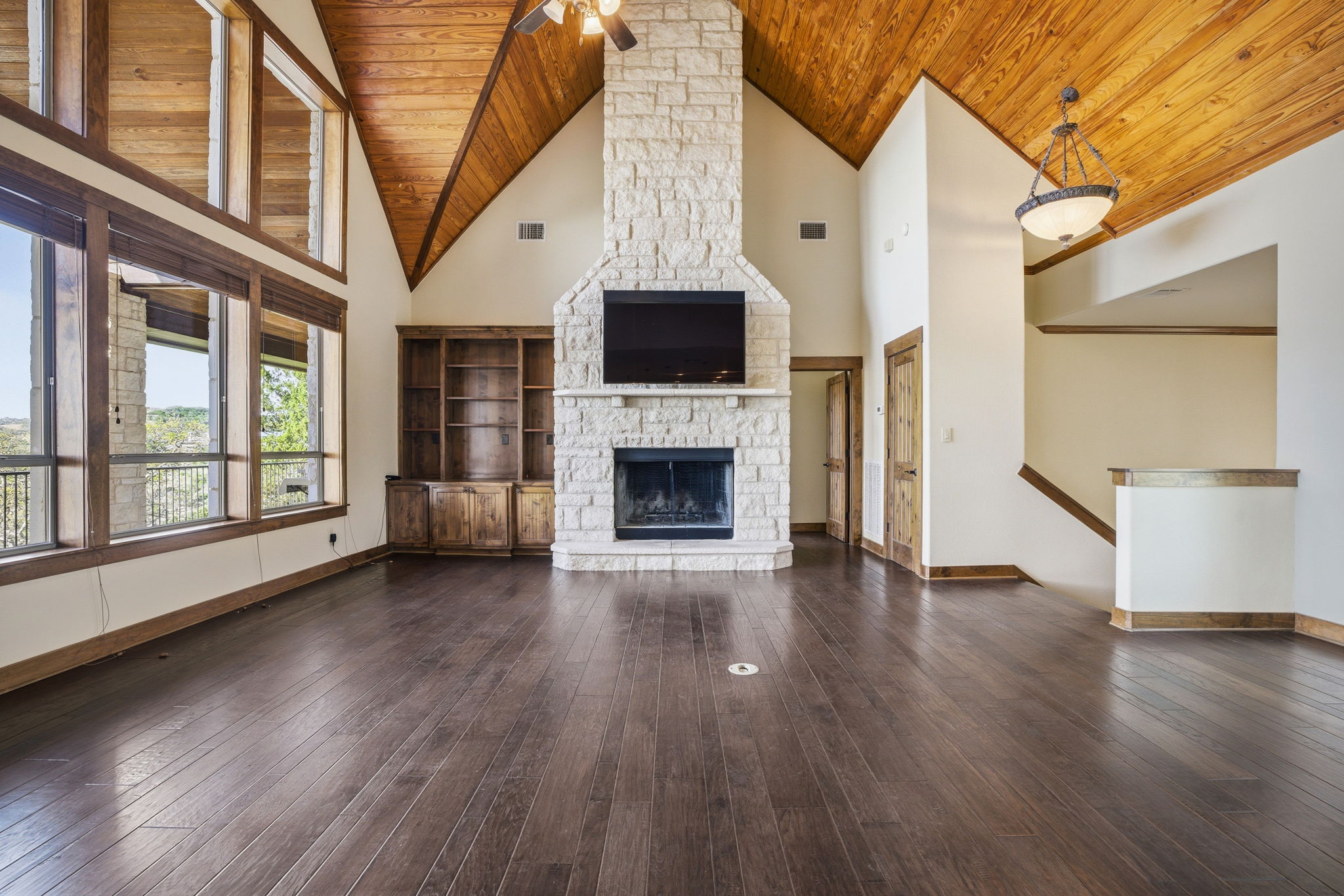 5010 Lookout Ridge Drive Marble Falls, TX 78654 - Photo 16 of 40 Unfurnished living room featuring a vaulted wooden ceiling, a ceiling fan, dark wood-style flooring, and a fireplace