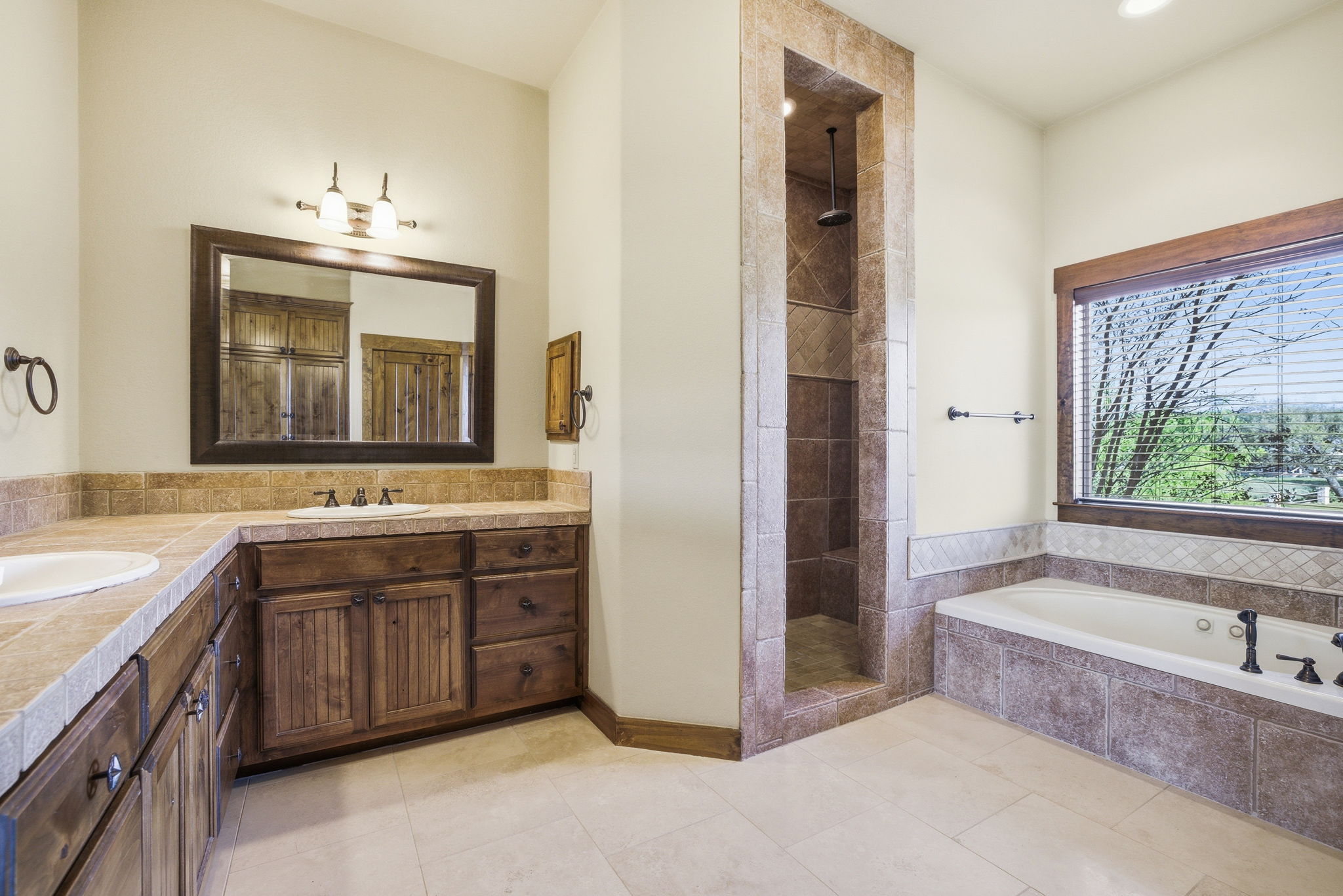 5010 Lookout Ridge Drive Marble Falls, TX 78654 - Photo 20 of 40 Bathroom with double vanity, a walk in shower, a bath, and light tile patterned floors