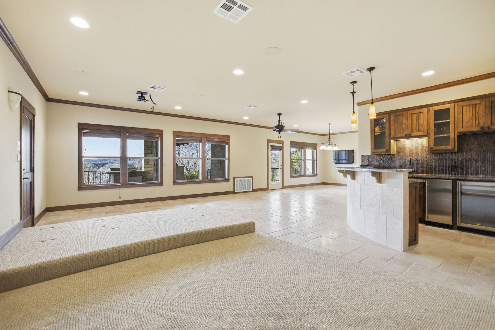 5010 Lookout Ridge Drive Marble Falls, TX 78654 - Photo 40 of 40 Kitchen with open floor plan, glass insert cabinets, stone tile floors, decorative light fixtures, and a kitchen breakfast bar