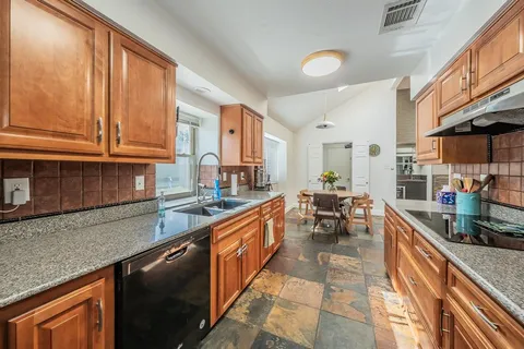 a kitchen with stainless steel appliances granite countertop a sink and cabinets