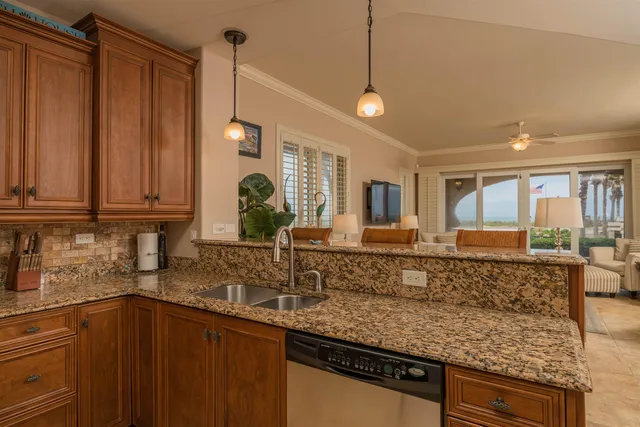 a kitchen with stainless steel appliances granite countertop a sink a stove a refrigerator and a refrigerator