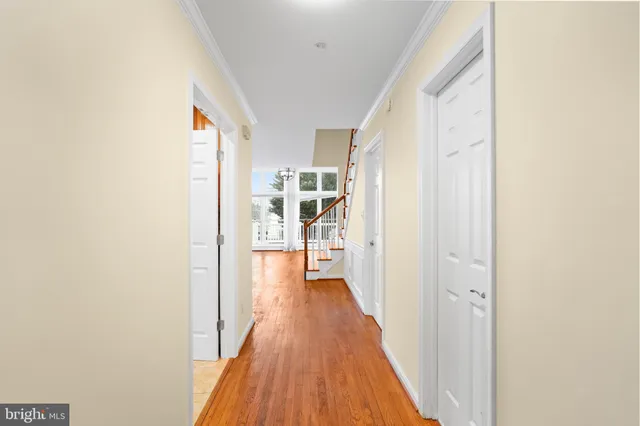 a view of a room with wooden floor and a ceiling fan