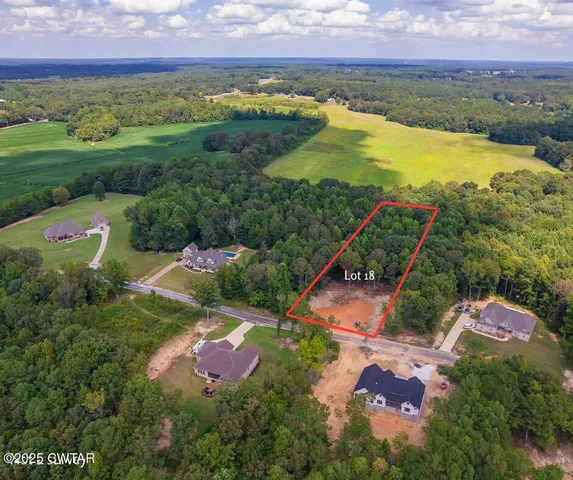 an aerial view of residential houses with outdoor space and lake view