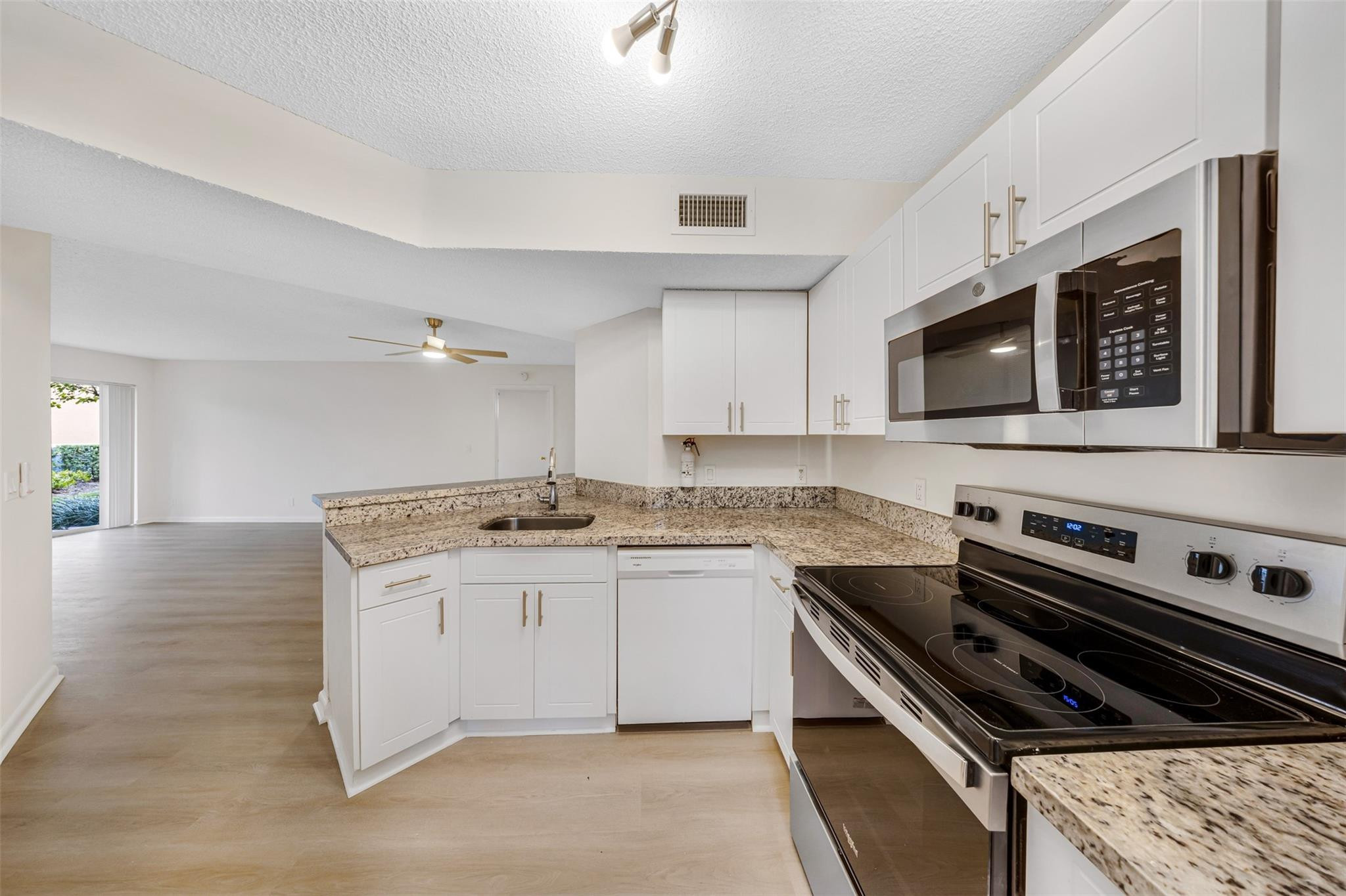8977 Wiles Road, Unit 102 Coral Springs, FL 33067 - Photo 1 of 37 a kitchen with a stove and a microwave