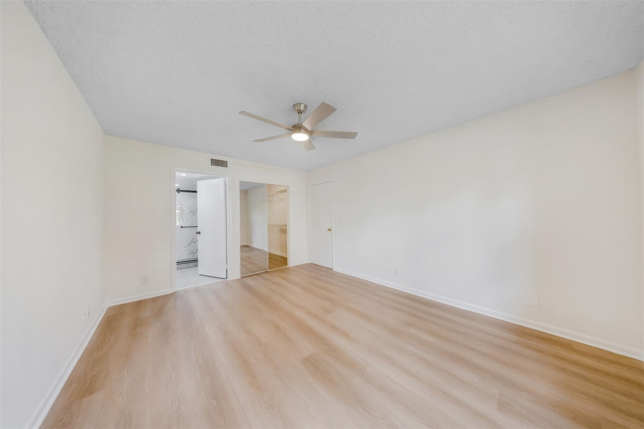 8977 Wiles Road, Unit 102 Coral Springs, FL 33067 - Photo 19 of 37 a view of an empty room with a chandelier fan