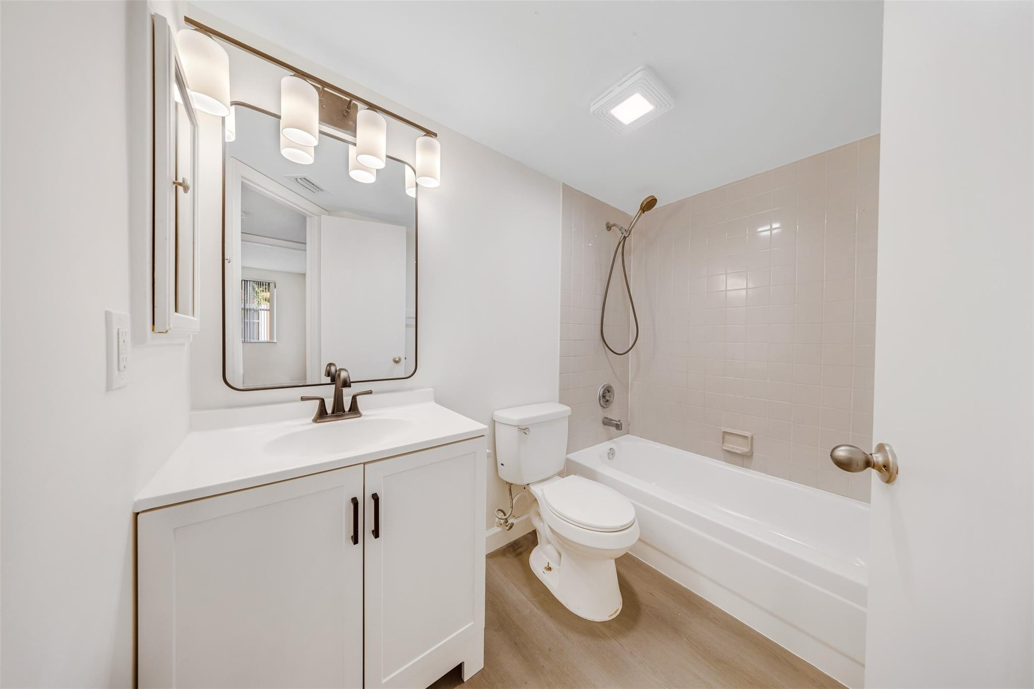 8977 Wiles Road, Unit 102 Coral Springs, FL 33067 - Photo 25 of 37 a bathroom with a toilet a sink and a mirror