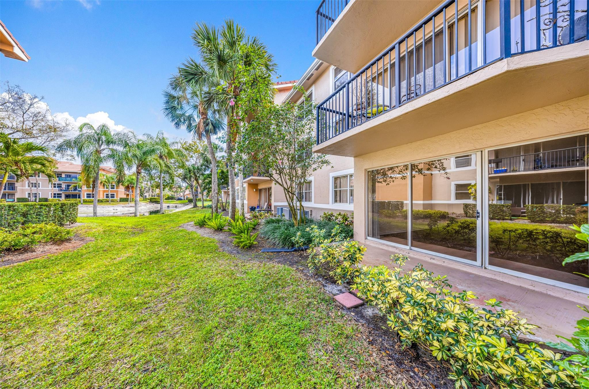 8977 Wiles Road, Unit 102 Coral Springs, FL 33067 - Photo 31 of 37 a view of a garden with a building in the background