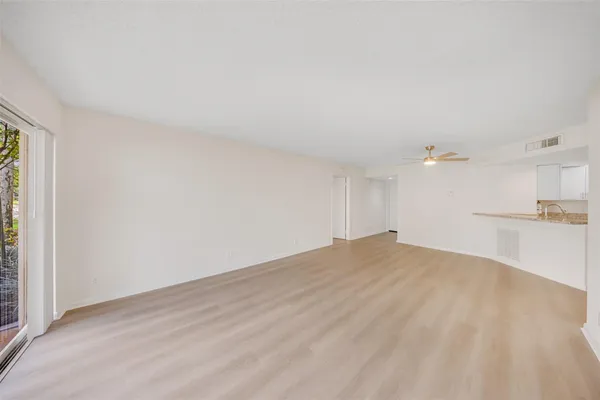 a view of a kitchen with wooden floor and a sink