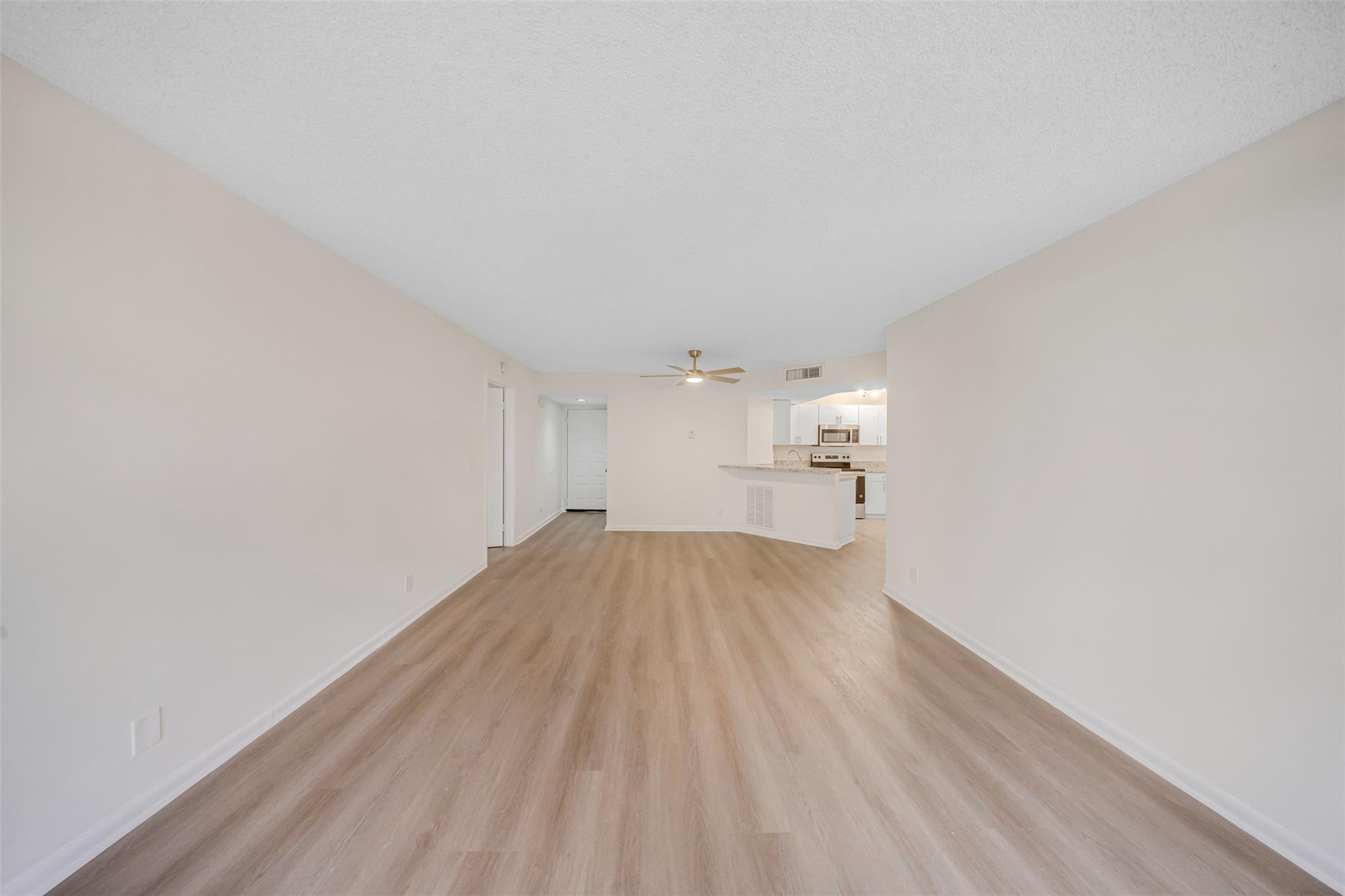 8977 Wiles Road, Unit 102 Coral Springs, FL 33067 - Photo 7 of 37 a view of empty room with wooden floor