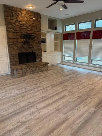 an empty room with wooden floor and fireplace