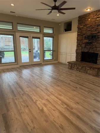an empty room with wooden floor and windows