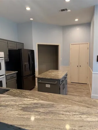 a kitchen with stainless steel appliances granite countertop a refrigerator and a sink