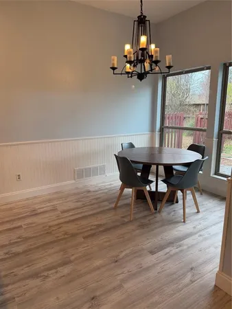 a view of a dining room with furniture wooden floor and chandelier