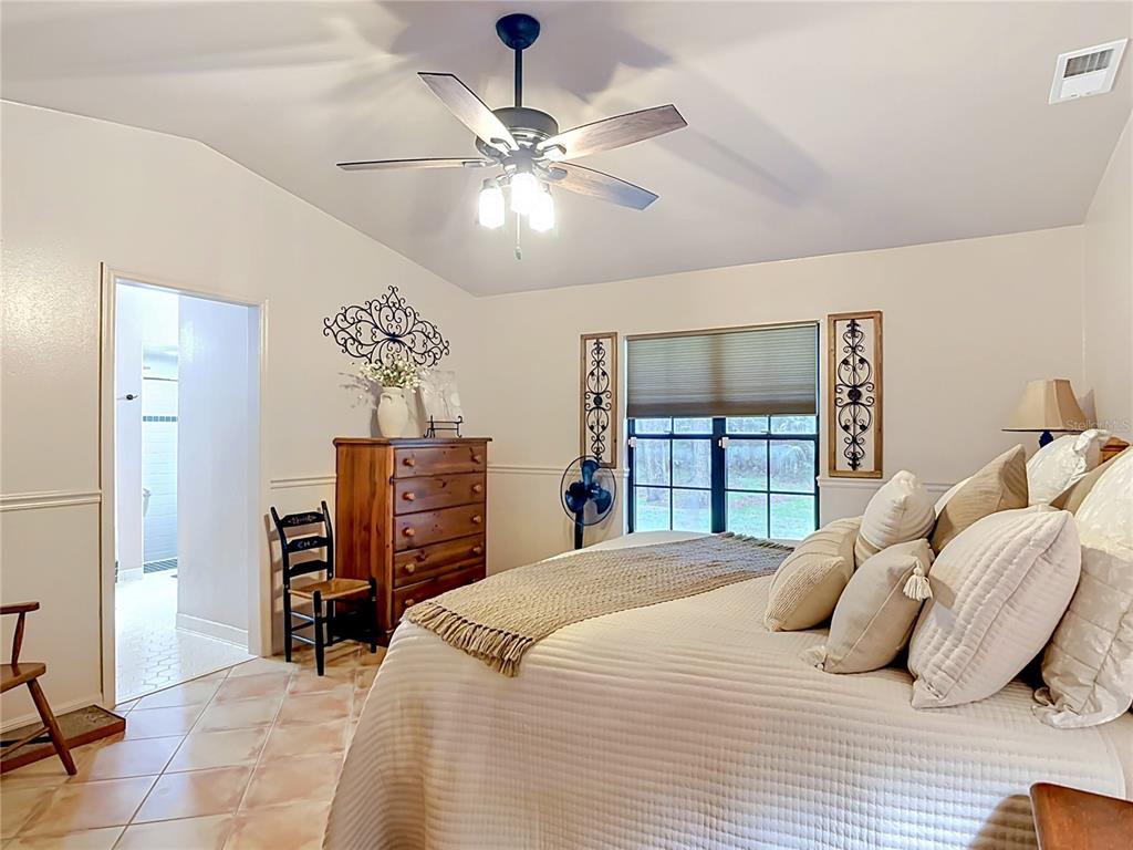 1395 Maytown Road Osteen, FL 32764 - Photo 32 of 65 a bedroom with a bed and a chandelier