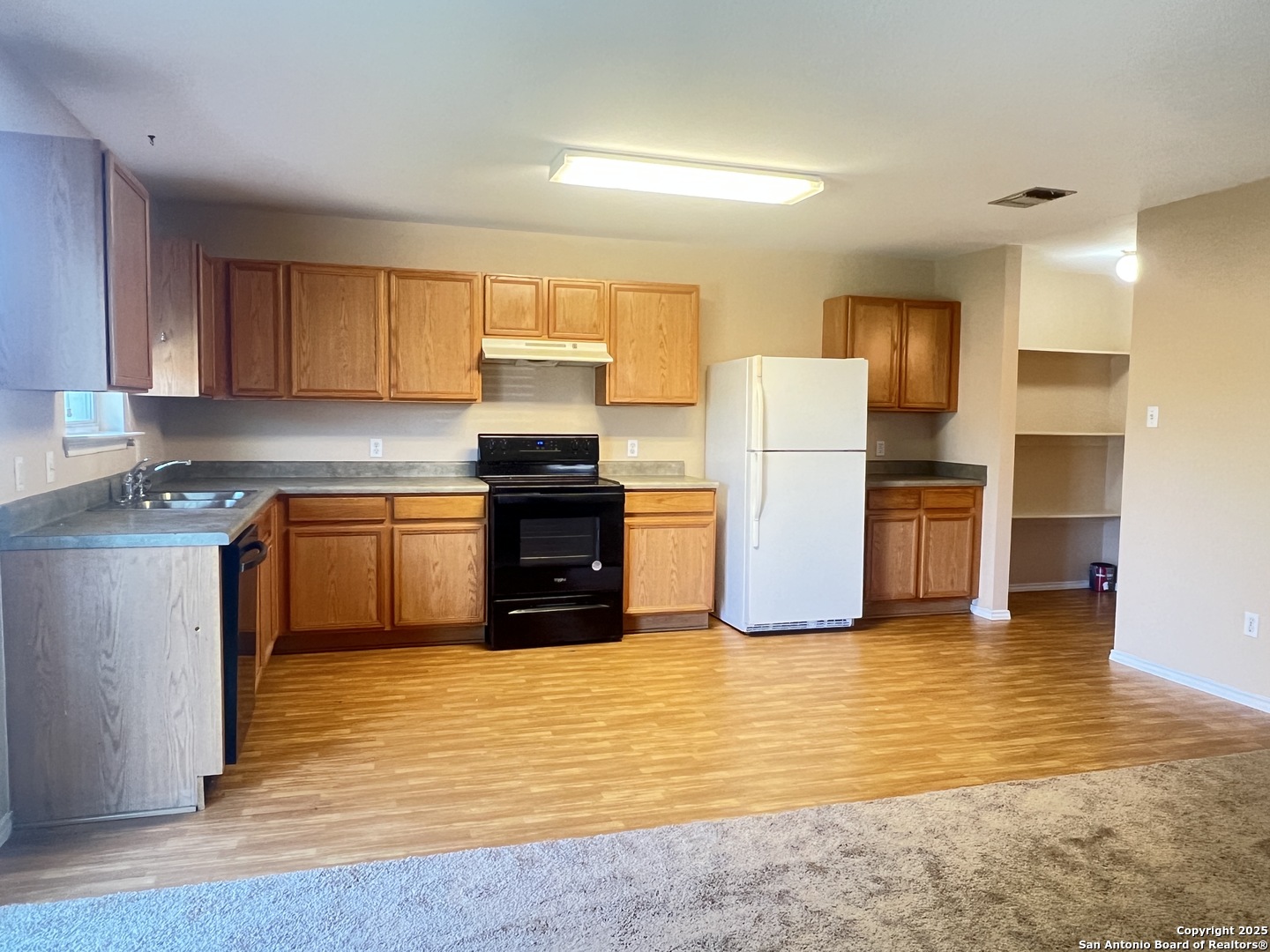 8163 Heights Valley Converse, TX 78109 - Photo 3 of 13 a kitchen with a sink a stove a refrigerator and cabinets
