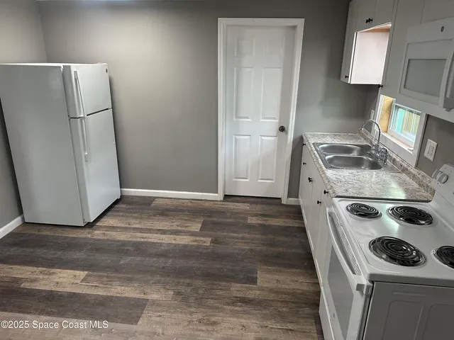 a kitchen with a stove top oven and sink
