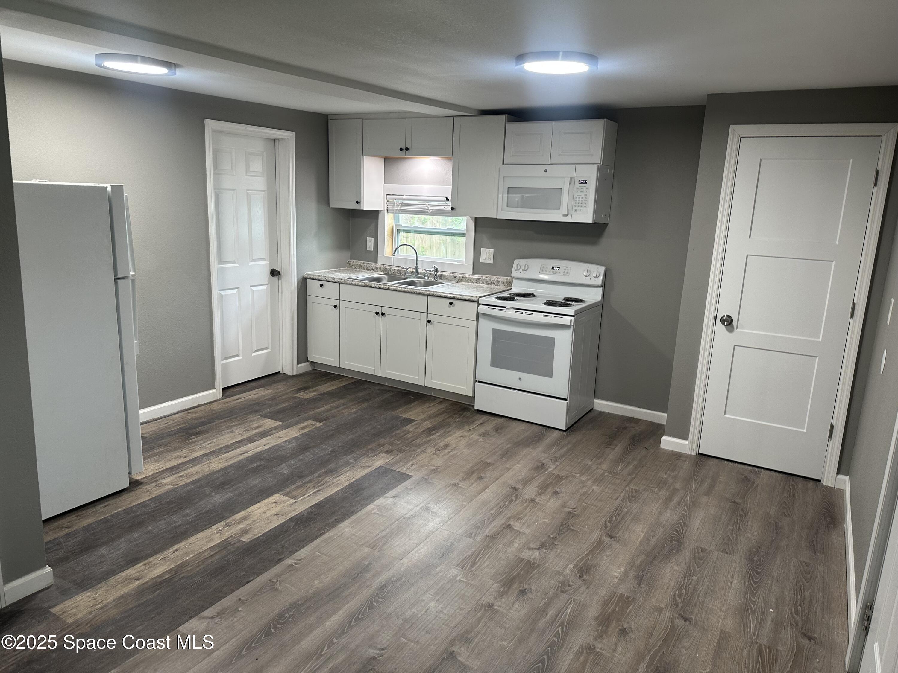 330 Palm Avenue, Unit 3 Cocoa, FL 32922 - Photo 4 of 6 a kitchen with stainless steel appliances a refrigerator sink and stove
