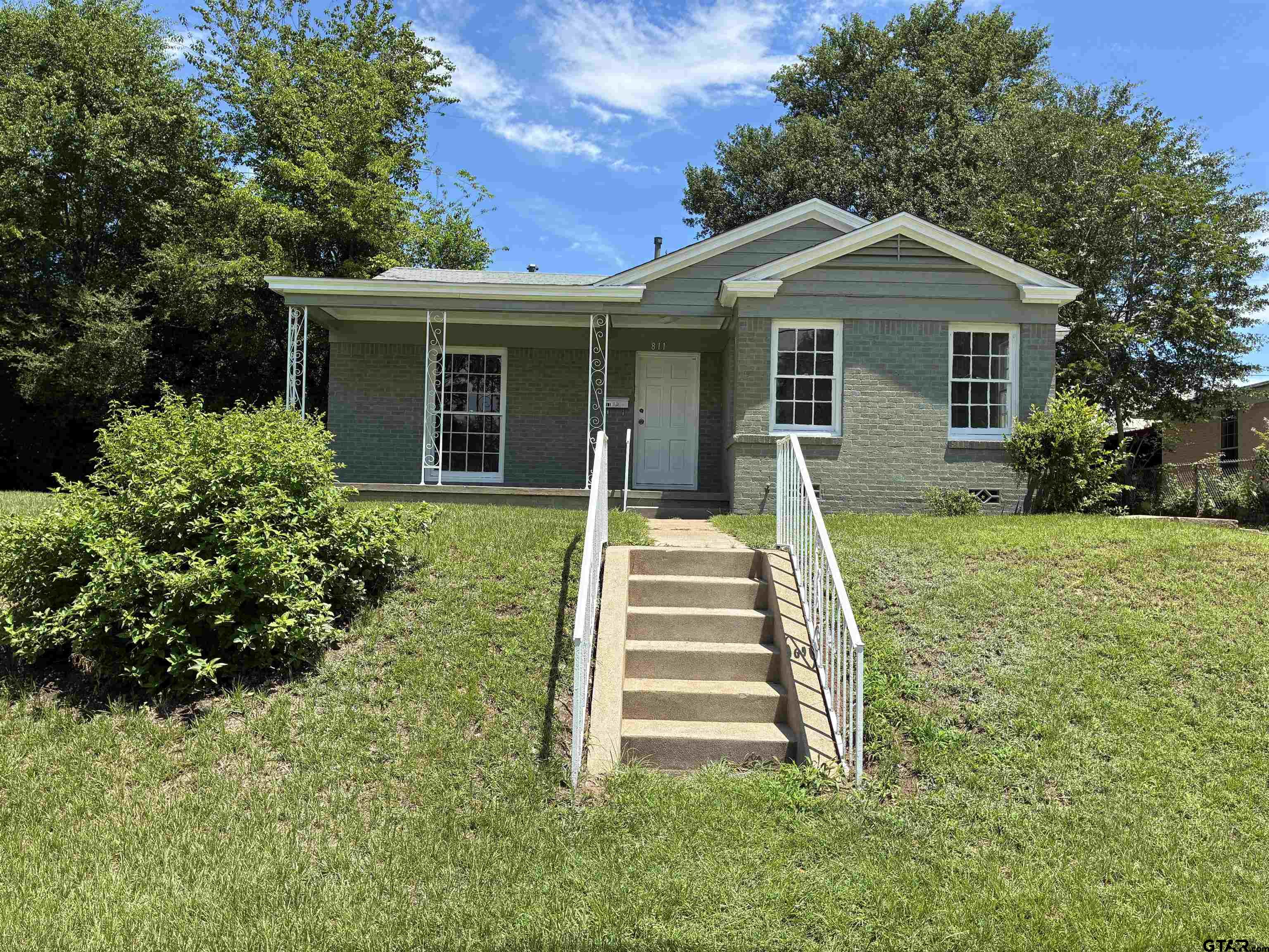 a front view of house with yard and green space