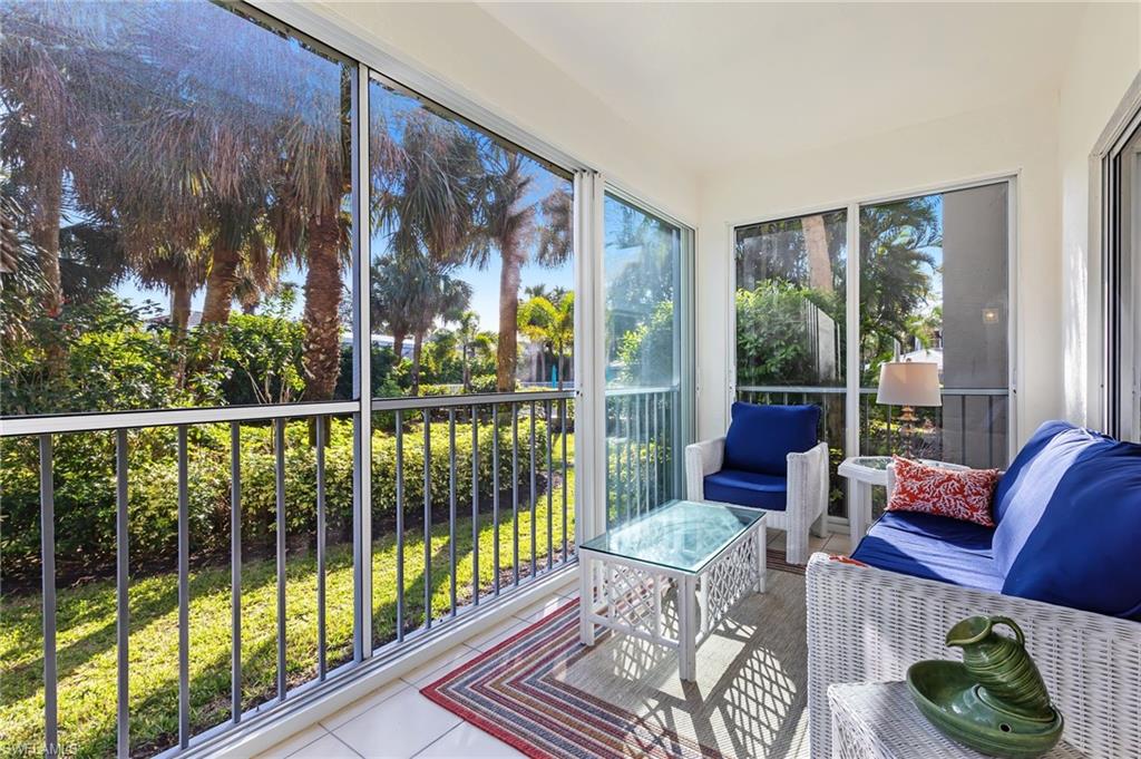 5899 Chanteclair Drive, Unit 214 Naples, FL 34108 - Photo 1 of 24 a living room with furniture and a floor to ceiling window