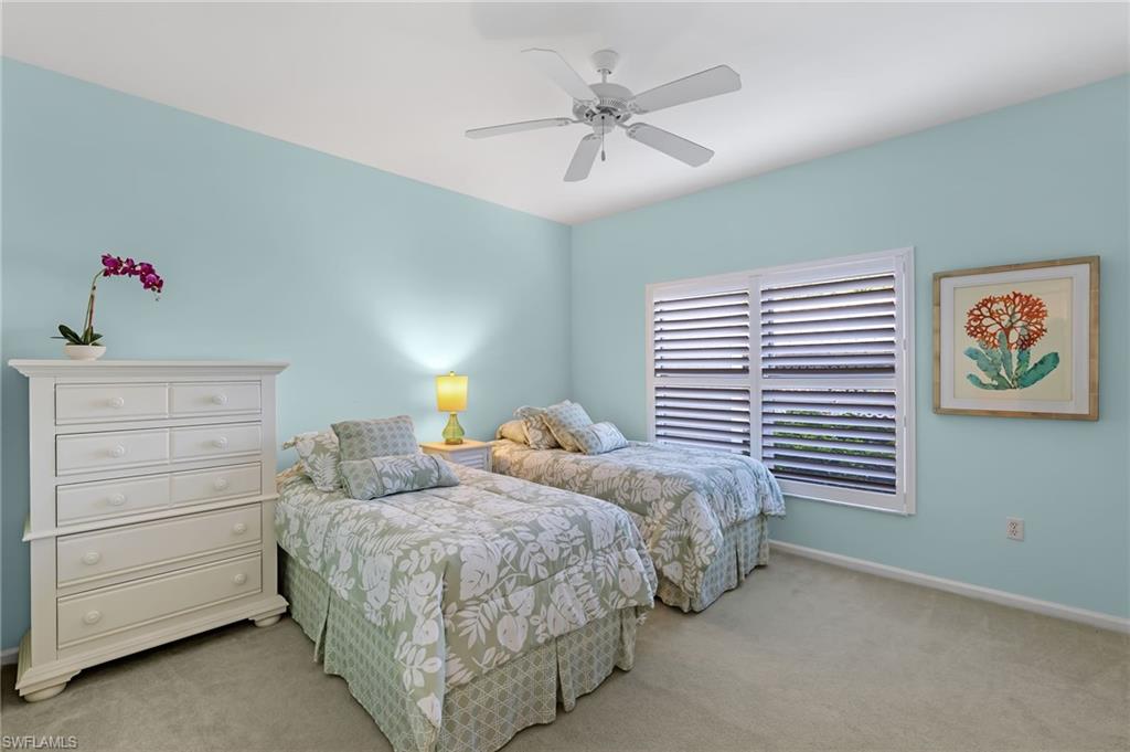 5899 Chanteclair Drive, Unit 214 Naples, FL 34108 - Photo 12 of 24 a bedroom with two beds and a chandelier