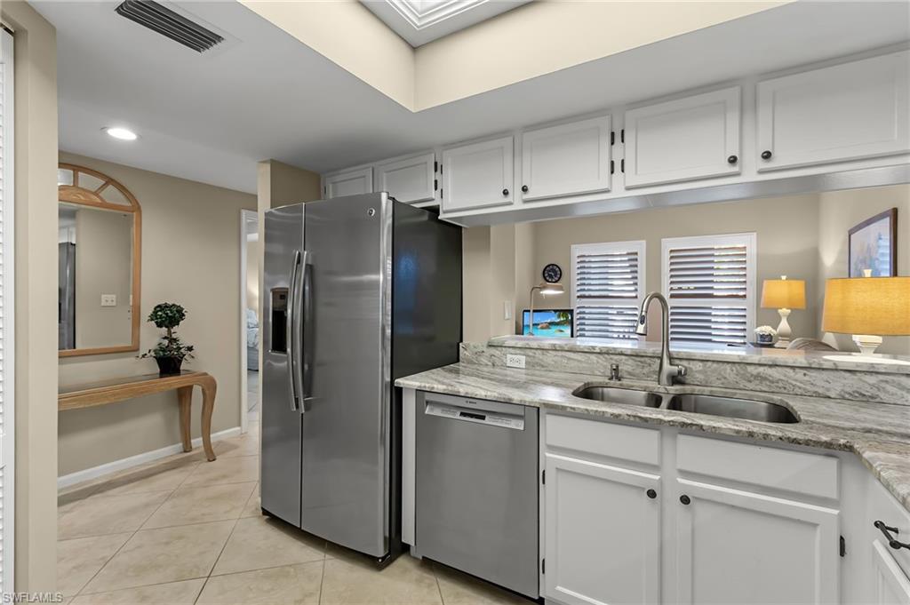 5899 Chanteclair Drive, Unit 214 Naples, FL 34108 - Photo 5 of 24 a kitchen with stainless steel appliances granite countertop a refrigerator and a sink