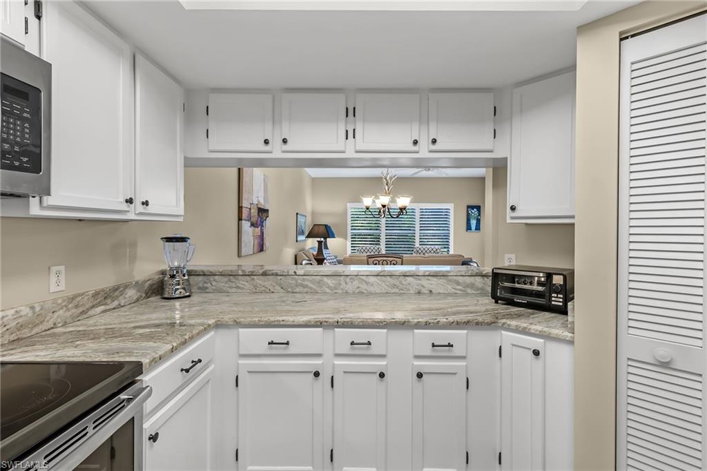 5899 Chanteclair Drive, Unit 214 Naples, FL 34108 - Photo 6 of 24 a kitchen with stainless steel appliances granite countertop a sink and cabinets