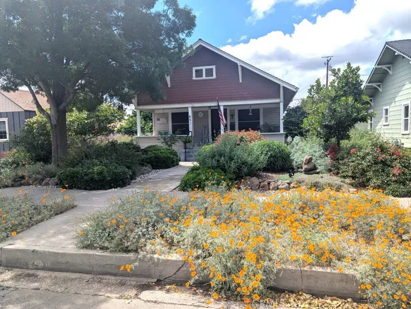 a front view of a house with a yard and trees