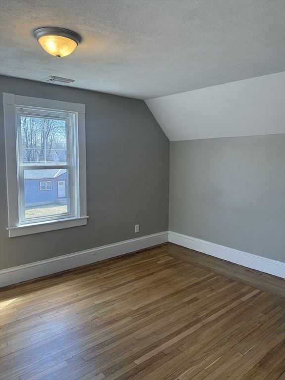 113 Union Street, Unit 2 Bridgewater, MA 02324 - Photo 8 of 9 a view of an empty room with wooden floor and a window