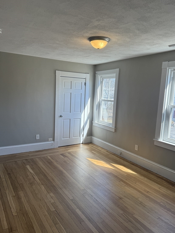 113 Union Street, Unit 2 Bridgewater, MA 02324 - Photo 9 of 9 an empty room with wooden floor and windows