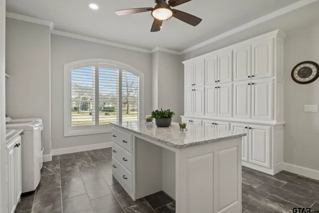 a kitchen with white cabinets and window
